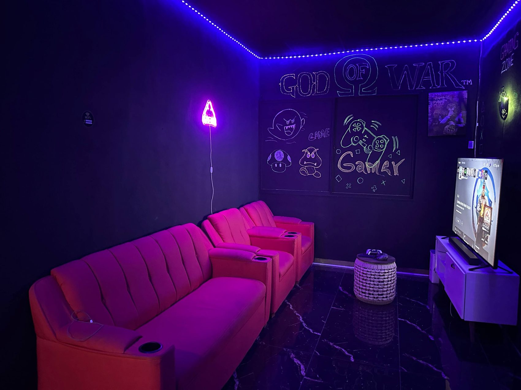 Zona gamer de Emperor Barber Studio con sillones, pantalla y luces ne&oacute;n