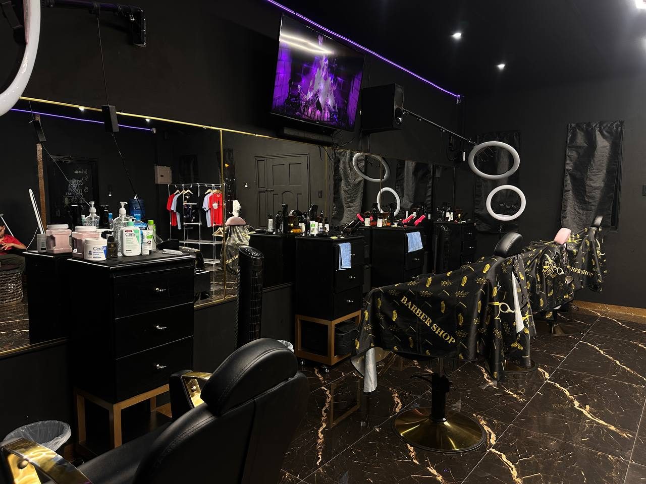 Ambiente interior real de Emperor Barber Studio con estaciones de corte y luces premium
