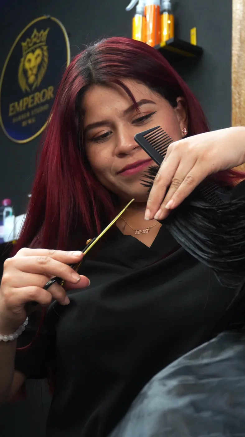 Keyling, con el cabello teñido, cortando con tijera y peine
